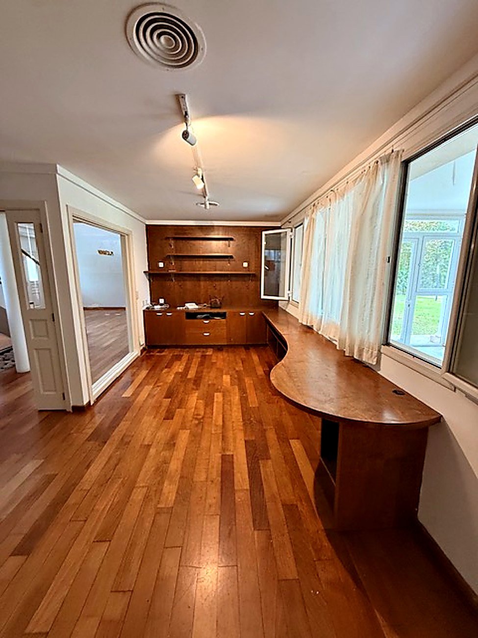Entertaining room with a curved solid wood bar counter, timber panelling and built-in cabinetry