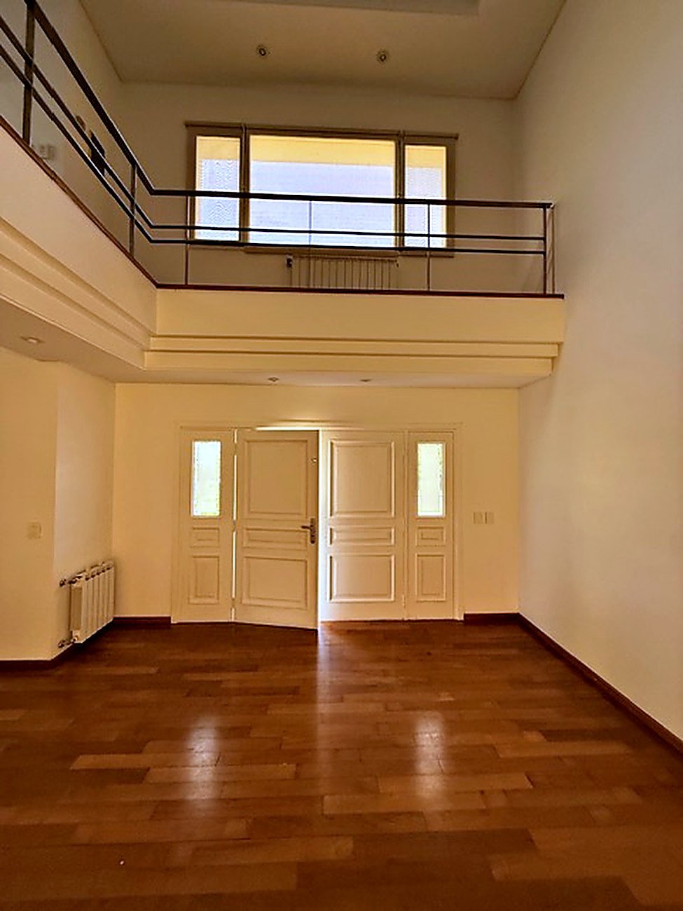 Double-height entrance hall with mezzanine walkway, clerestory window and panelled front doors