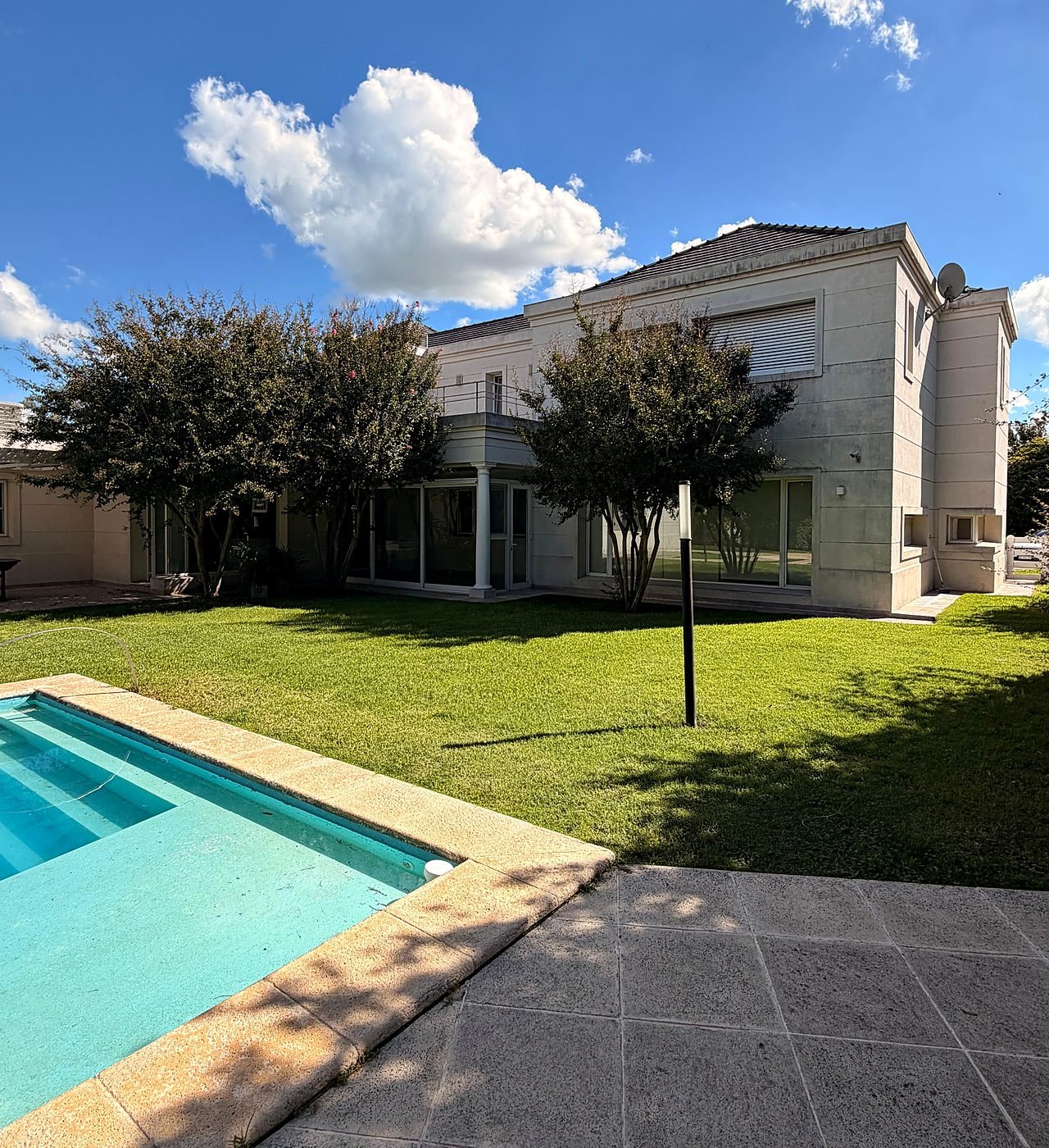 Rear of the house across the lawn, with the swimming pool in the foreground