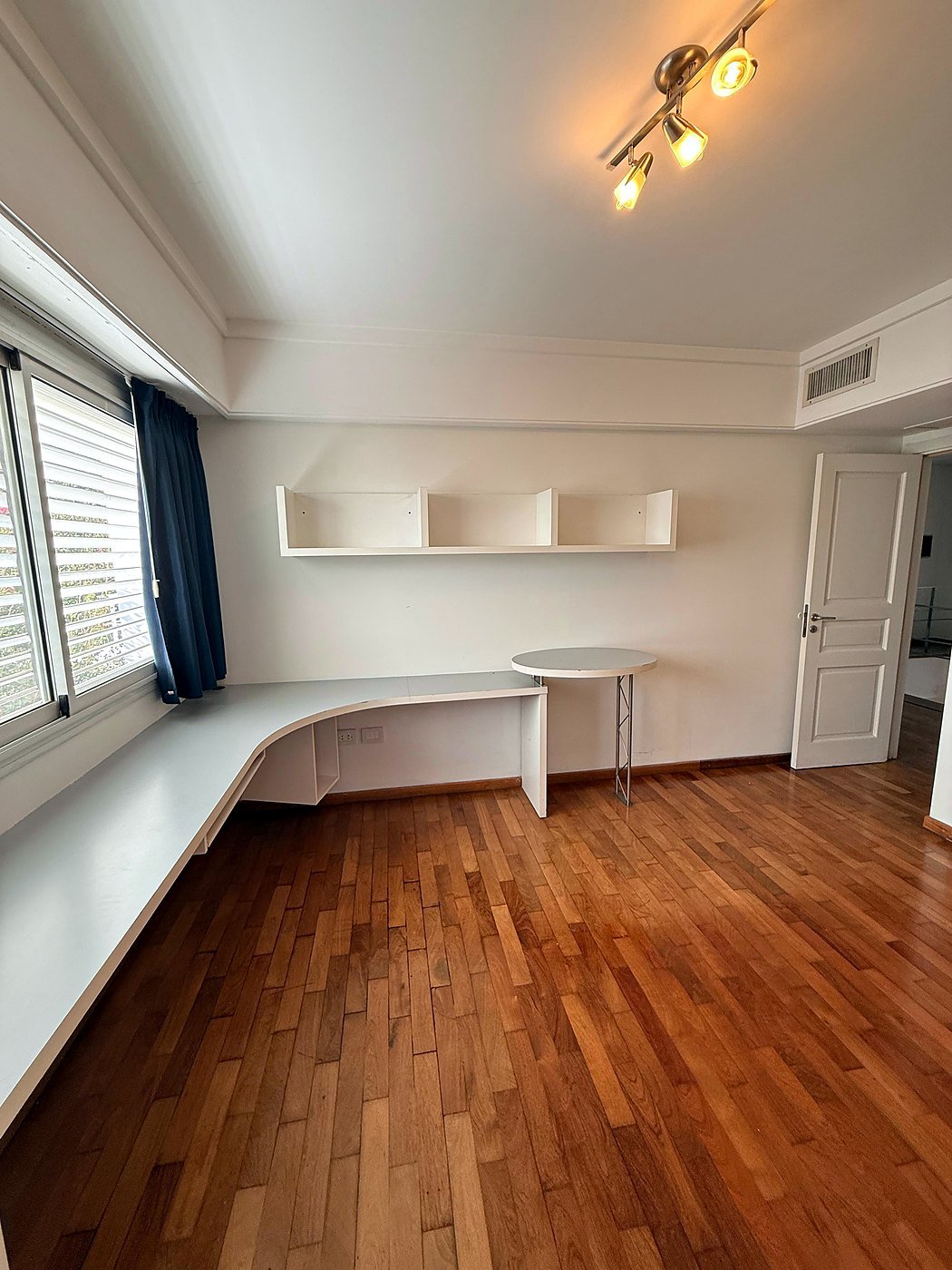 Home study with a curved built-in desk running under a wide window, Funes, Greater Rosario