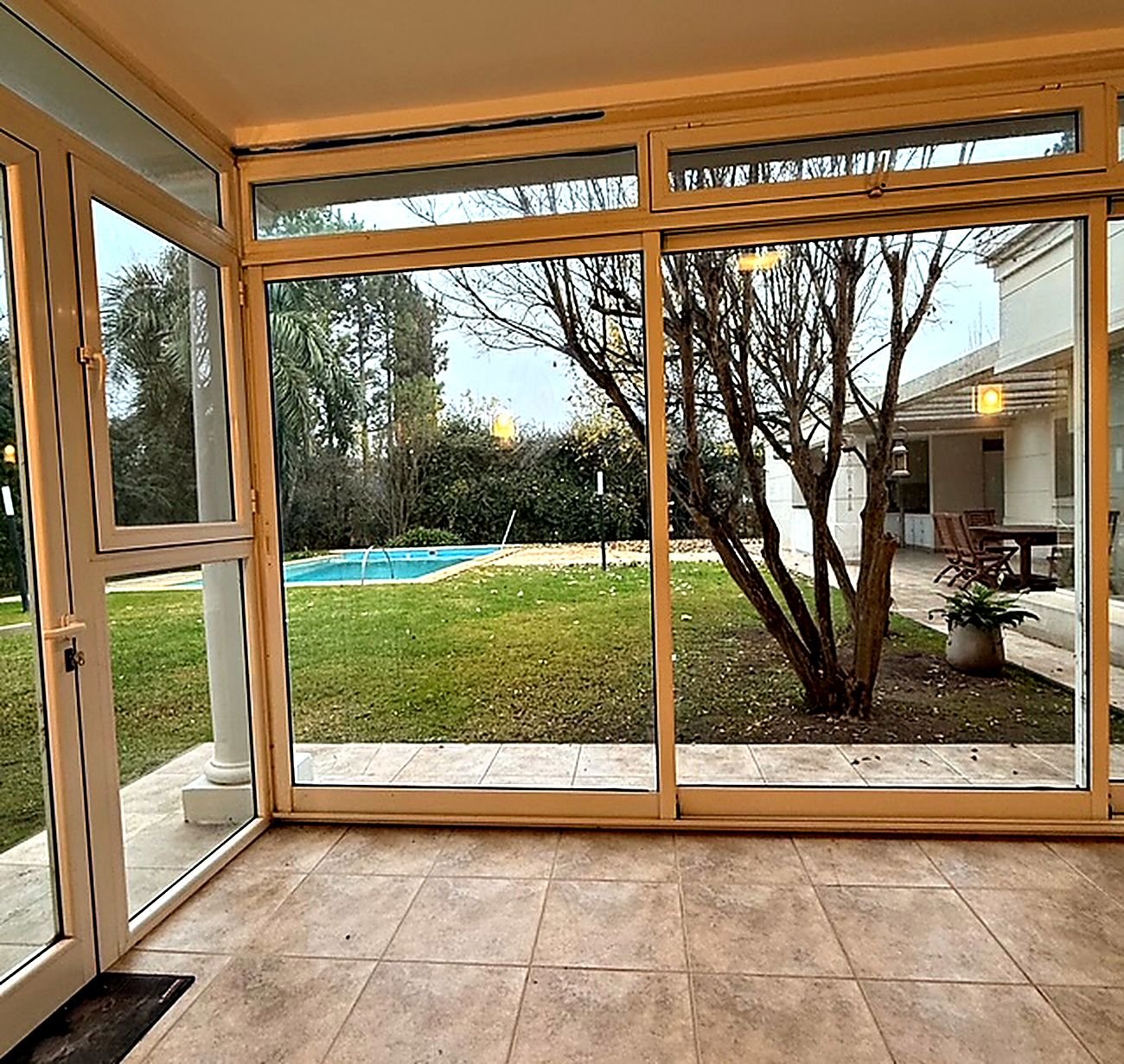 Glazed winter garden framing the pool and the park